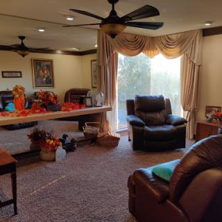 A cozy living room featuring a recliner, decorative elements, and natural light flowing in through a window.