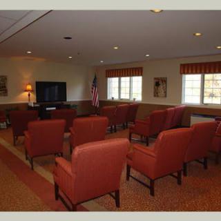 A conference room with rows of chairs facing a television.