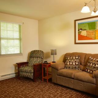 A cozy living room featuring a comfortable sofa, an armchair, and decorative artwork on the wall.