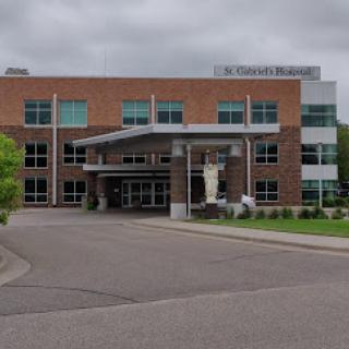 The front facade of a modern healthcare facility on a cloudy day.