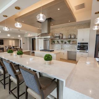 A modern luxury kitchen featuring elegant design elements, spacious layout, and stylish bar seating.