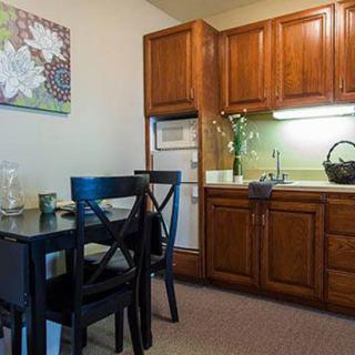 A cozy kitchen with wooden cabinets and a small dining area.