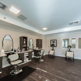 A modern salon interior with chairs and mirrors arranged for hairstyling.