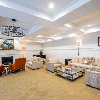 A modern living room with elegant furnishings, featuring a large sofa, armchairs, and a stylish coffee table centered around a fireplace.