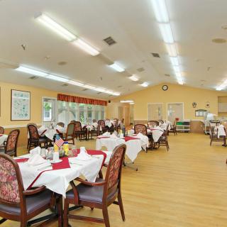 A spacious dining area with neatly arranged tables and chairs, ready for guests.