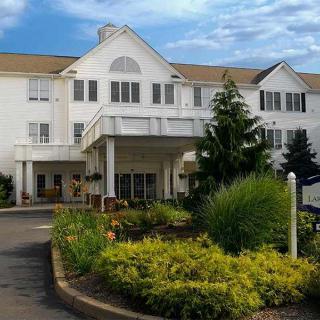 A scenic view of a hotel's exterior with well-maintained landscaping and clear blue skies.