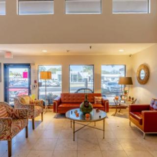 A cozy and well-decorated lobby area with a modern touch, featuring sofas, chairs, and a coffee table.