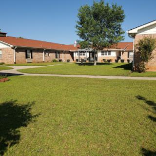 A sunny day in a residential area featuring well-maintained lawns and buildings.