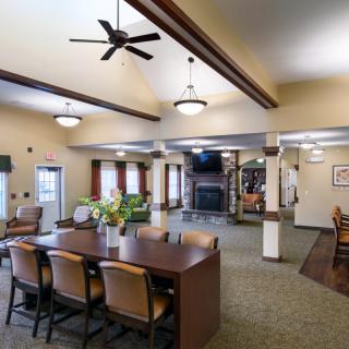 Spacious dining area with a large table, chairs, ceiling fan, and fireplace.