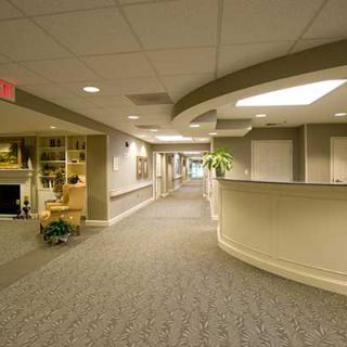 A modern office hallway with a reception area and seating.