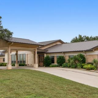 A modern single-story house with a driveway and landscaped front yard.