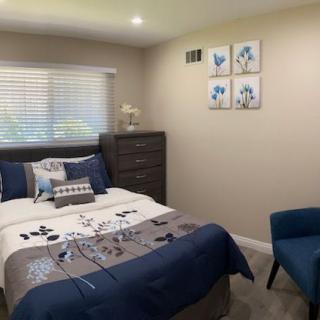 A cozy bedroom with modern decor, featuring blue accents and stylish furniture.