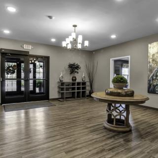 A modern lobby entrance with stylish decor and a central round table.