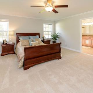 A cozy and well-lit bedroom featuring a wooden bed set and ceiling fan.