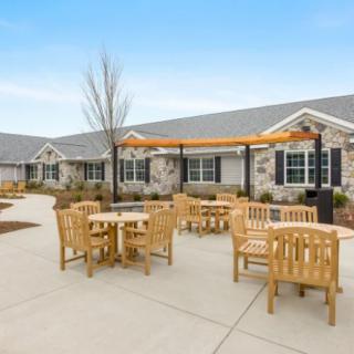 A patio area with wooden furniture in front of a residential building.
