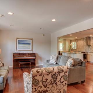 A cozy living room with elegant furniture and a view into the kitchen.