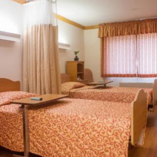 A hospital room with twin beds and privacy curtain.