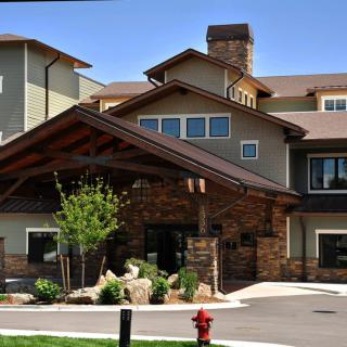 A modern residential building with a covered entrance and landscaped surroundings.
