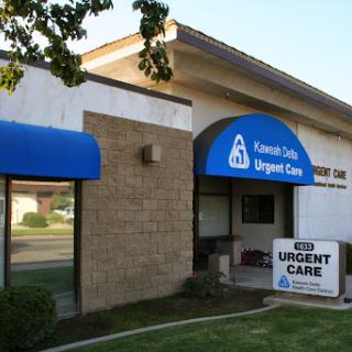 Exterior view of a Urgent Care facility with a blue awning and signage.