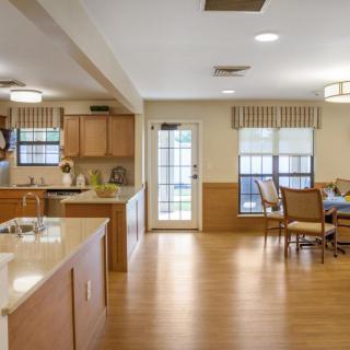 A spacious kitchen and dining area with wooden flooring and ample natural light.
