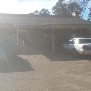 A sunny day view of a building with parked cars in the foreground.