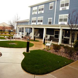A well-maintained garden area in front of a three-story residential building.