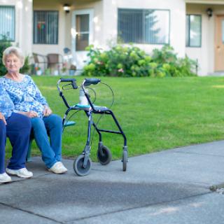 Two elderly women enjoying a moment outdoors in a community setting.