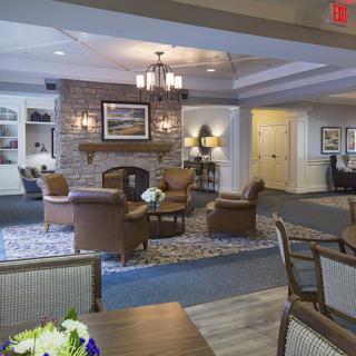 A cozy living room with comfortable seating around a fireplace, featuring elegant interior design elements.