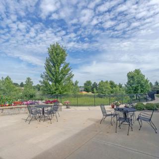 Outdoor patio area with tables and chairs overlooking a scenic landscape.