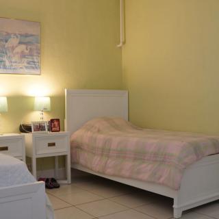 A cozy bedroom with twin beds and a shared nightstand with two lamps.