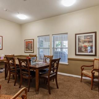 A cozy dining room with a wooden table, chairs, and framed artwork on the walls.
