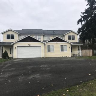 A two-story suburban house with a garage and driveway.