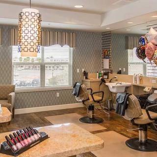 A stylish salon interior with comfortable chairs and a display of nail polishes.