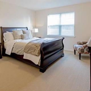 A cozy bedroom with elegant wooden furniture and a large window.