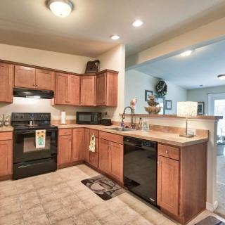 A modern kitchen with wood cabinets, black appliances, and an open layout.