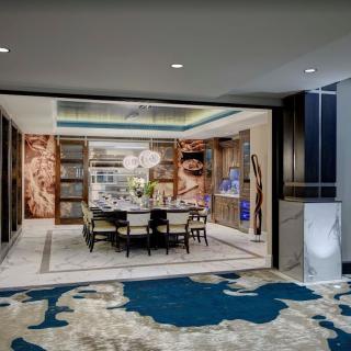 A luxurious, modern dining room featuring elegant furniture, artwork, and a stylish carpet.