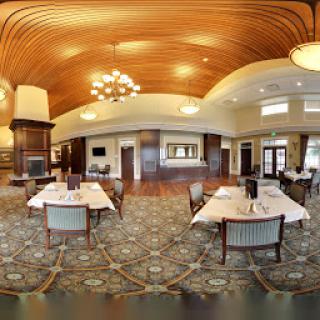 A spacious and elegantly designed dining area featuring wooden ceilings and stylish furnishings.