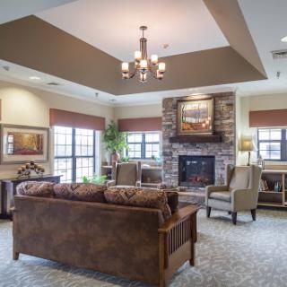 A cozy and modern living room featuring comfortable seating, a fireplace, and ample natural light.