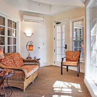 A cozy sunroom with wicker furniture, large windows, and ample natural light.