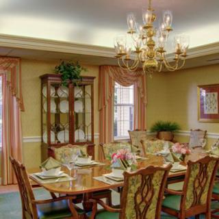 An elegant dining room with a beautifully set table and a chandelier overhead.
