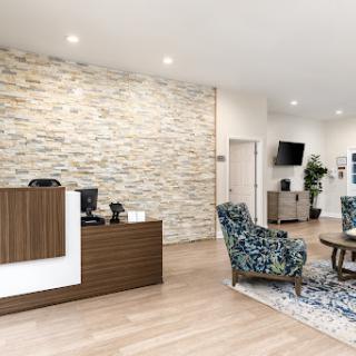 A modern reception area featuring a blend of stylish furniture and a stone accent wall.