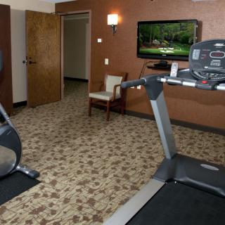 A small indoor gym with exercise equipment including a treadmill and a stationary bike.