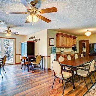 Spacious dining and kitchen area with wood flooring and ceiling fans.