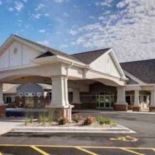 A healthcare facility with a prominent entrance and adjacent parking area.