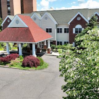 A charming residential building with a red roof and well-maintained landscaping.
