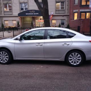 A silver sedan parked on an urban street.