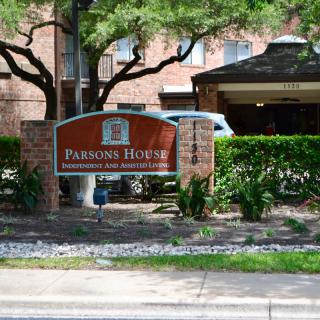 Entrance sign for Pearson House surrounded by trees and hedges.