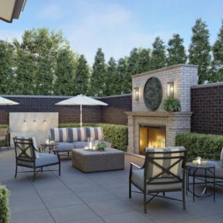 A cozy outdoor patio with comfortable seating and a fireplace.