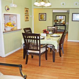 A cozy dining room with a wooden table and chairs, surrounded by tasteful decor and artwork.