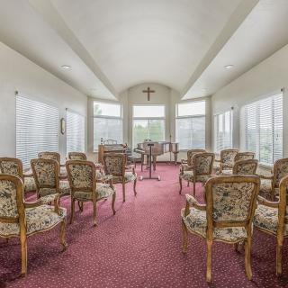 A serene chapel interior with elegant seating and large windows.